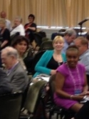 adults listening to a female speaker at a seminar