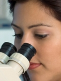 woman in lab using microscope