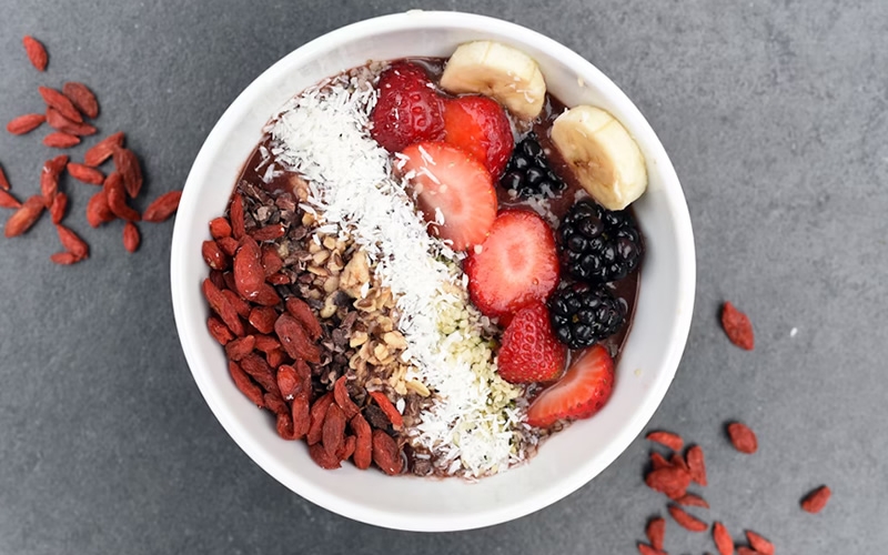 Nuts and berries in a white bowl.