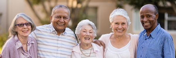 smiling seniors standing with arms around each other