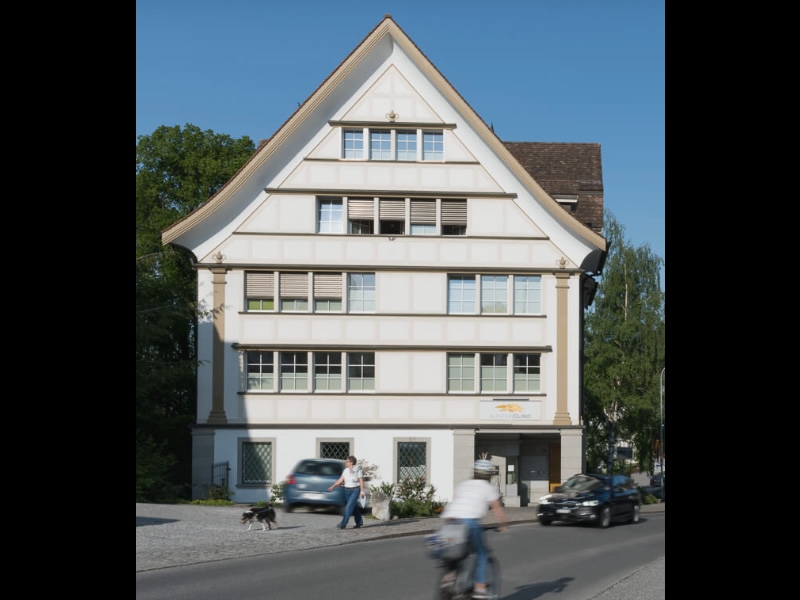 Alpstein Clinic: white building with steep peaked roof and many windows on a clear blue sky day