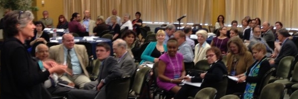 adults listening to a female speaker at a seminar