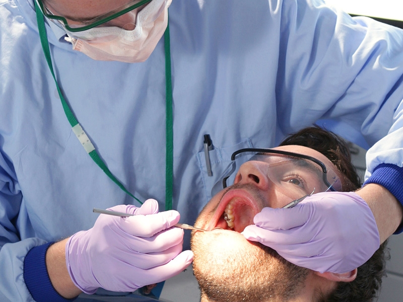 dentist working on man with mouth open