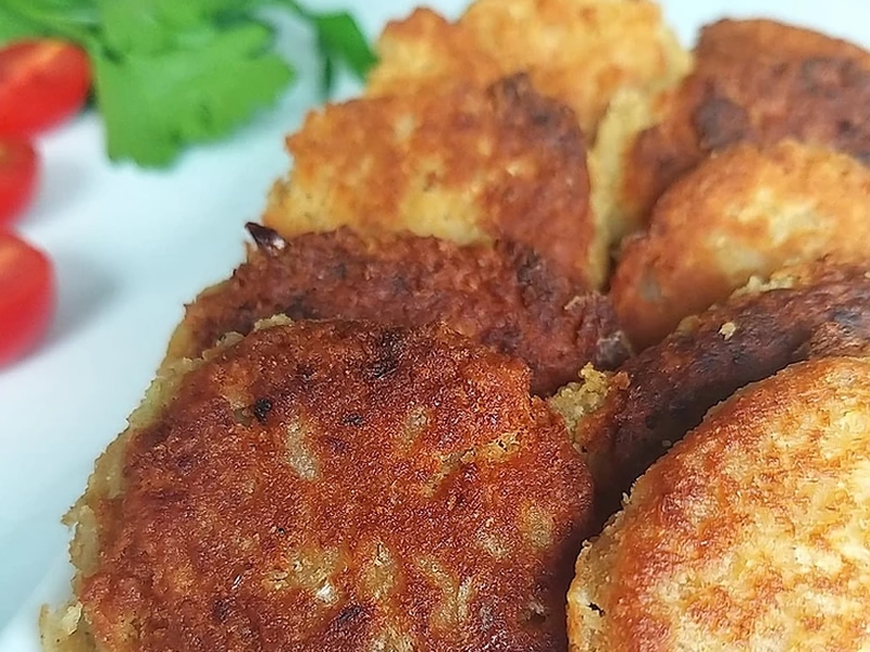 Golden brown fried falafel with tomatoes and lettuce on the side