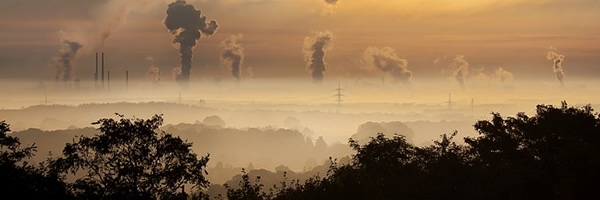 sun glints off smoke and haze from multiple smoke stacks