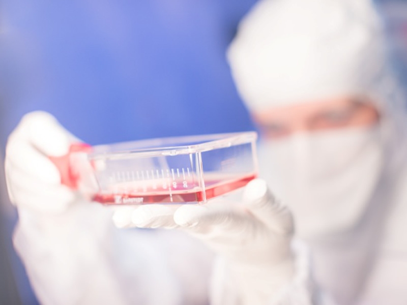 researcher in white protective suit testing lab samples