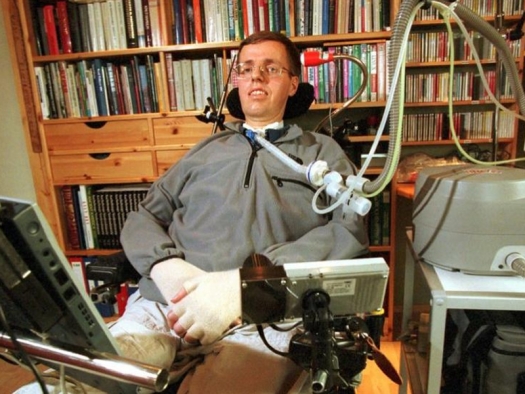 Per Villand, a man with ALS, seated at his desk with computer and breathing machine