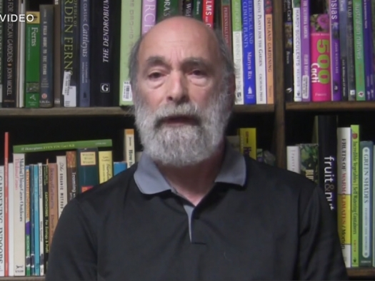 David Getoff seated in front of book case introducing his course