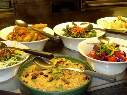 Buffet with different food in bowls on table