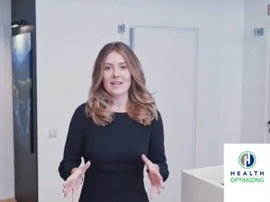 Hannah Kathleen standing in an office with white walls describing the clinic