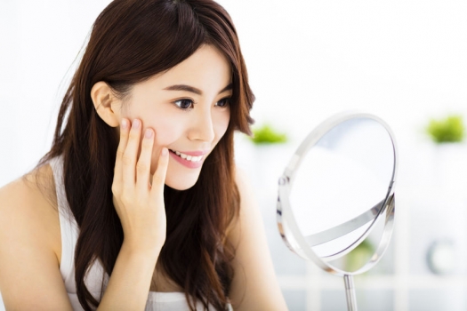 woman looking at face in mirror