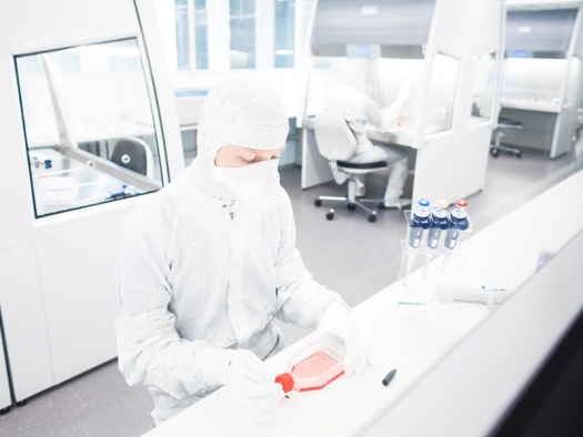 researcher working in a clean room wearing protective white suit