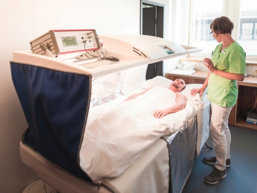 patient in hyperthermia bed with medical staff nearby