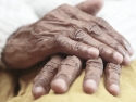 close up of a pair of hands of an older person, folded on a lap