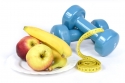 apples and bananas on a plate next to a tape measure and small weights