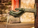 sculpture of a pair of hands catching water