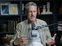 Mark Hyman in front of microphone with bookcase in background