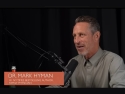Mark Hyman seated at table with a microphone.