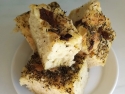 Chunks of focaccia bread with herbs on top on white plate