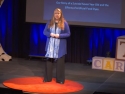 Rebecca Bevans speaking on stage at TEDxCarsonCity, 2016