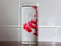 tall glass of water with red food dye suspended in water before dissolving