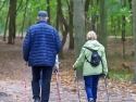 Senior citizens on a hike in the woods with ski poles for hiking sticks
