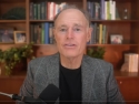 David Perlmutter with microphone; wide bookcase with books, pictures, and plants on shelves in background