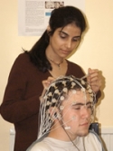 Dr. Aditi Shankardass places electrodes on patient's head.